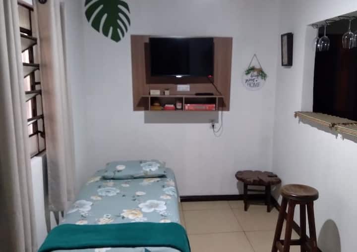 Habitación con cama supletoria, TV inteligente de 32 pies y ventilador de techo.