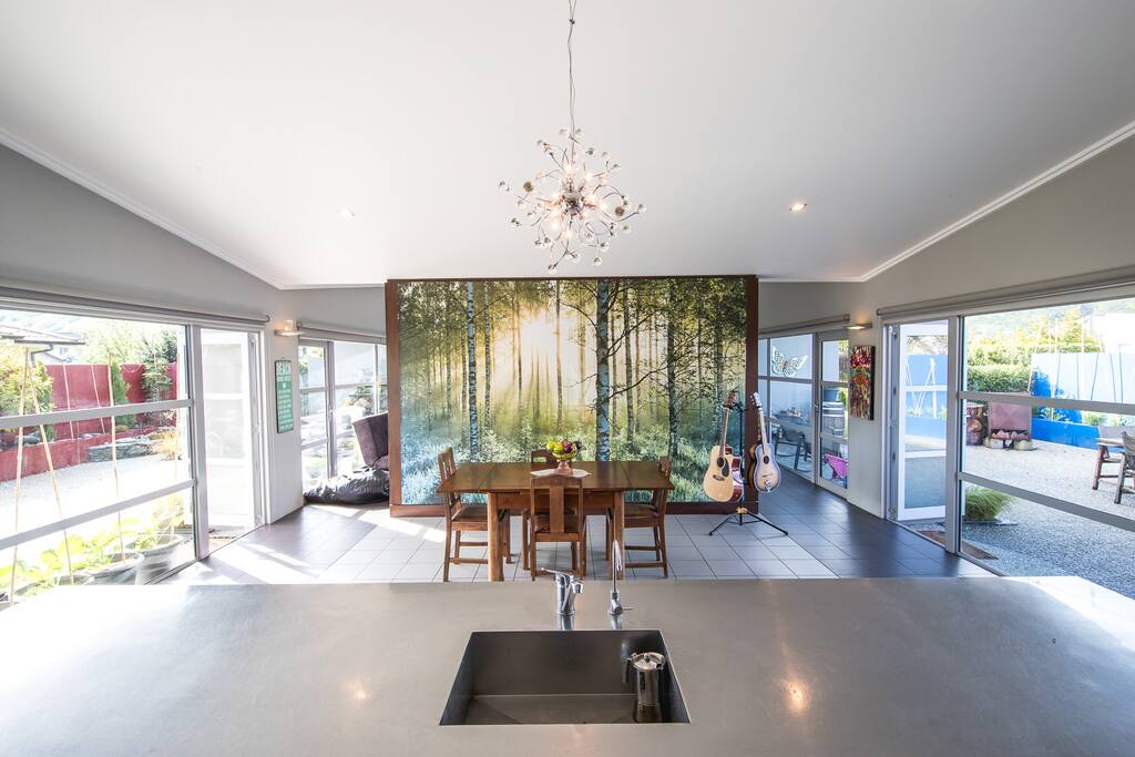 Looking across the stainless steel kitchen island towards the living area