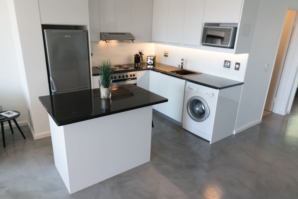 fully equipped kitchen with granite tops and washing machine