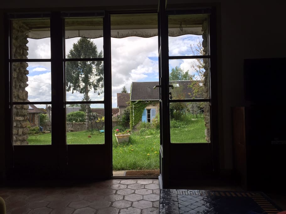 La maison s'ouvre sur la cour verdoyante de la ferme..