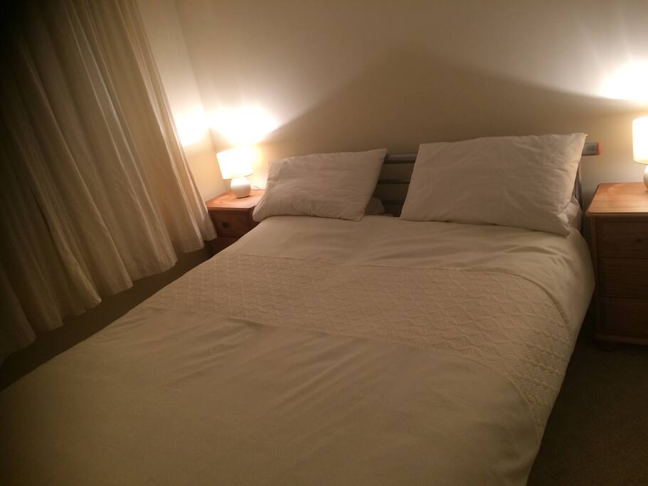 Cosy king size bed with 2 chests of drawers and fitted, mirrored wardrobe