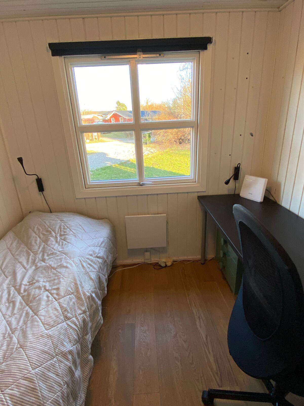 Habitación con escritorio y cama individual.