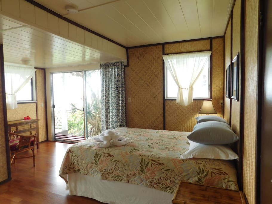 A spacious bedroom with amazing views from all windows and two huge glass slider doors onto the SHARED lanai (veranda) and lawn.