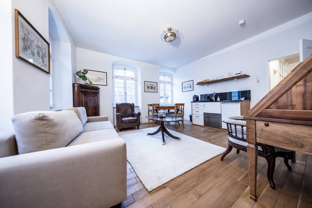 Das Wohnzimmer mit Sitzbereich und kleiner Küche