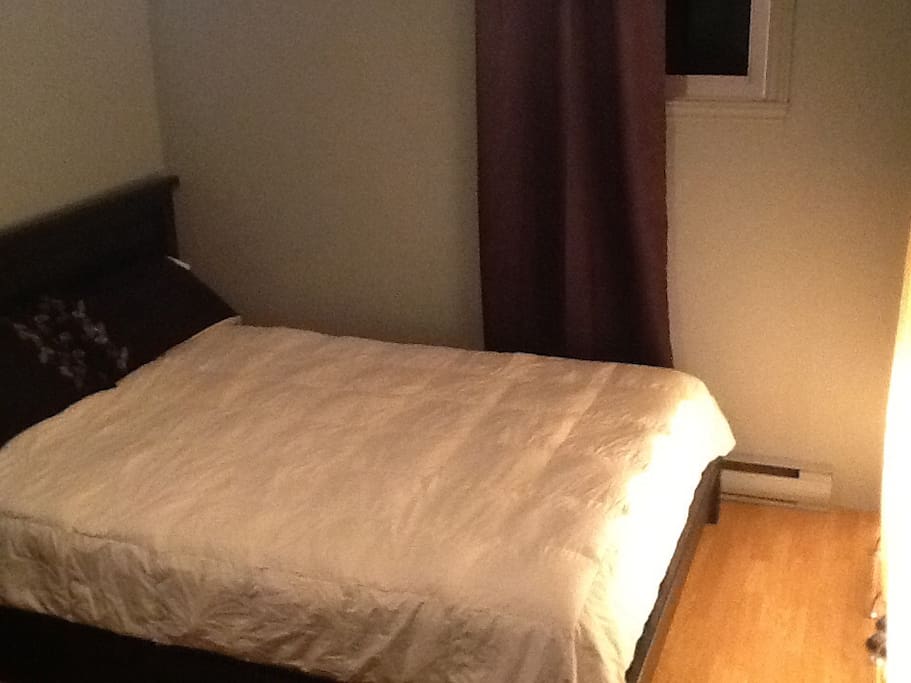 Un lit queen confortable avec couette en duvet