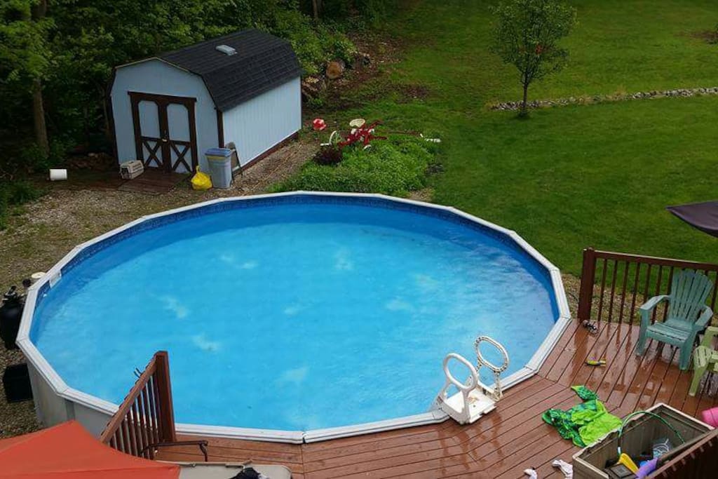 Large above ground swimming pool with deck and lounge chairs