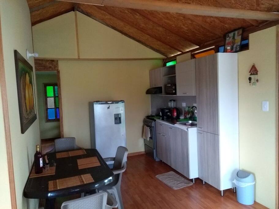 Cocina integral, nevera y comedor.