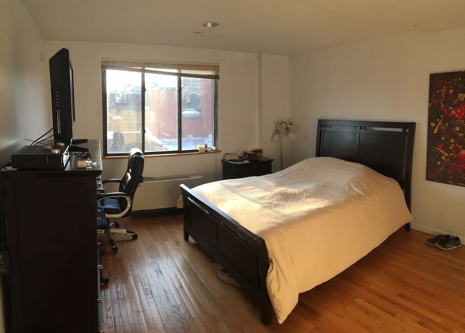 Queen size bed, desk, full closet and extra room to get ready. View from bed of the World Trade Center.