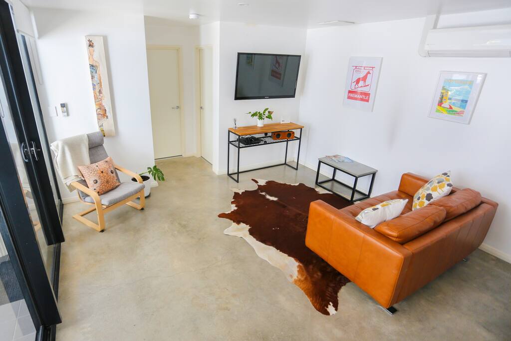 Homely and modern living area with quality furniture and large TV