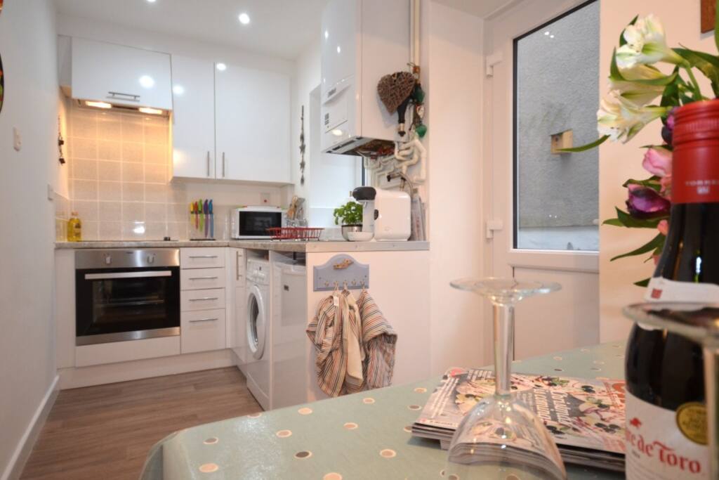 Kitchen/diner with door to courtyard. Auto washing machine, microwave, toaster, kettle, fridge, Bosch pod coffee maker. Pro Cook pots n pans.