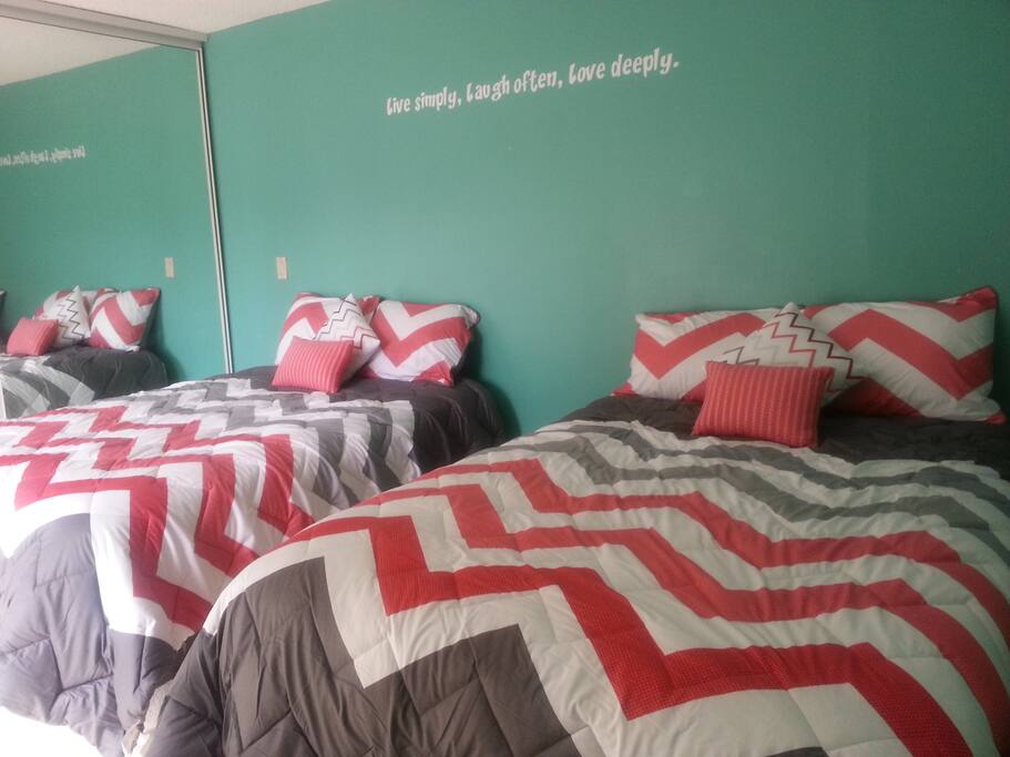 Second bedroom with two full size beds, dresser and huge mirrored closet length of the room.
