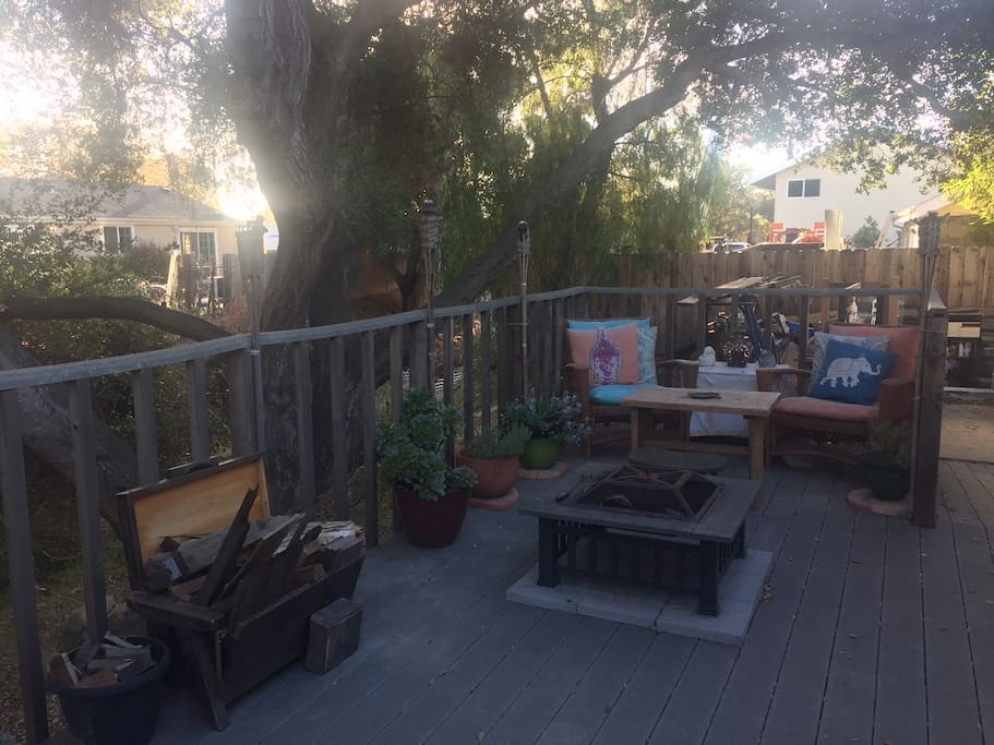 Wooden deck off the back entrance with seating area and fire pit