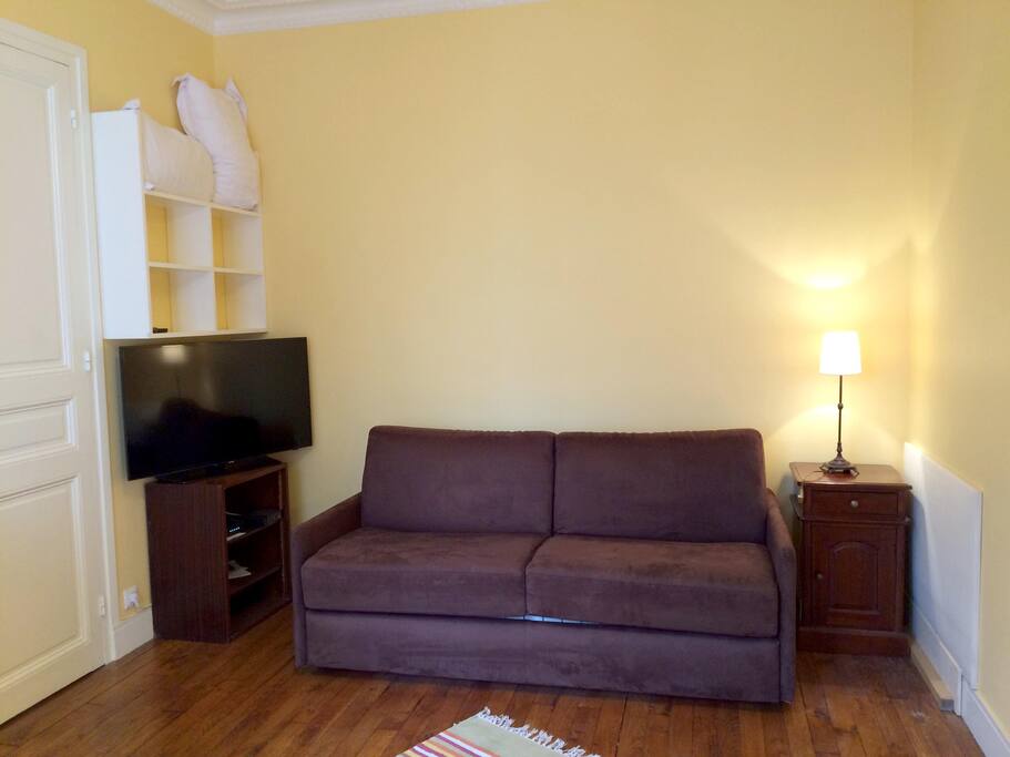 Le canapé lit est très simple d'utilisation. TV 40" 102cm. Une chambre à la couleur chaleureuse, haute de plafond, aux meubles chinés