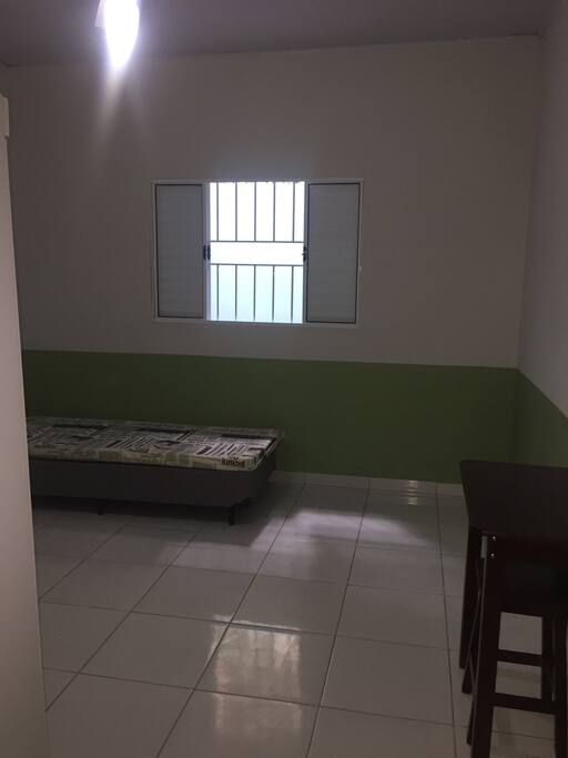 Boxe e colchão, pequena mesa para computador, ventilador no teto.