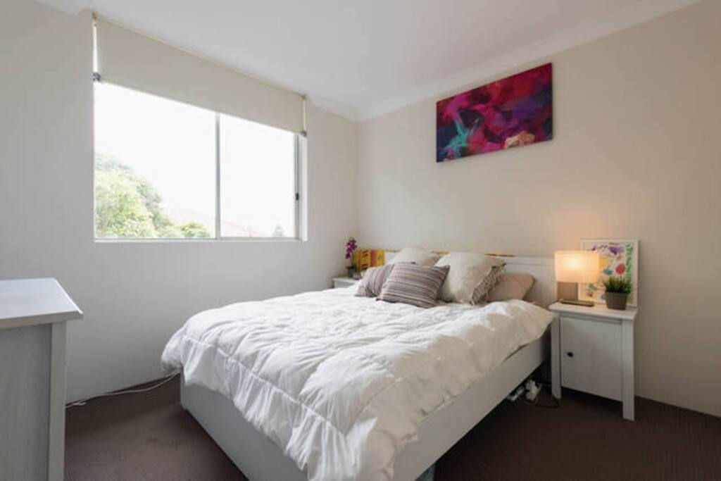 Larger bedroom with queen size bed, TV & built in wardrobe.