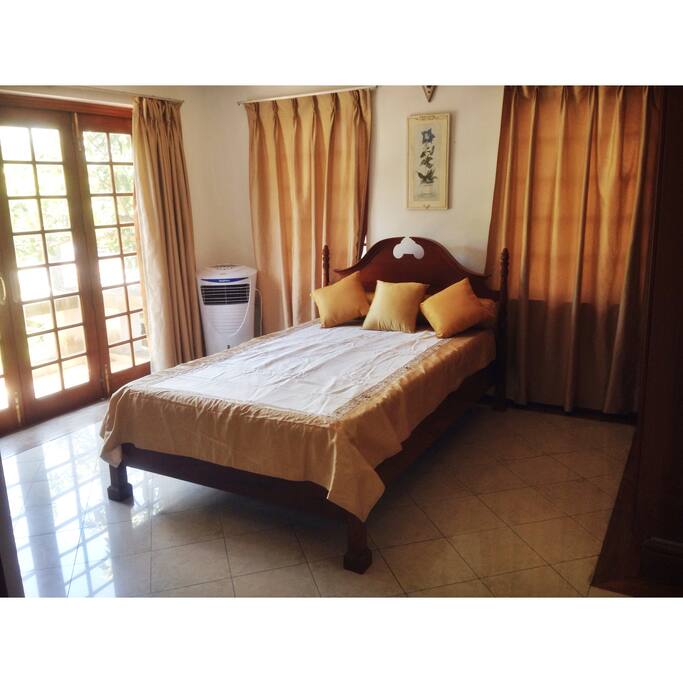 A cozy, sun filled room with a portable A/C
