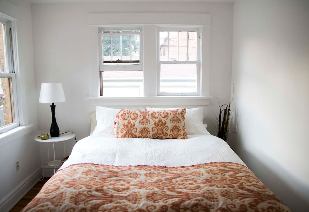 Queen-sized bed in the bedroom with custom-made throw and pillow covers