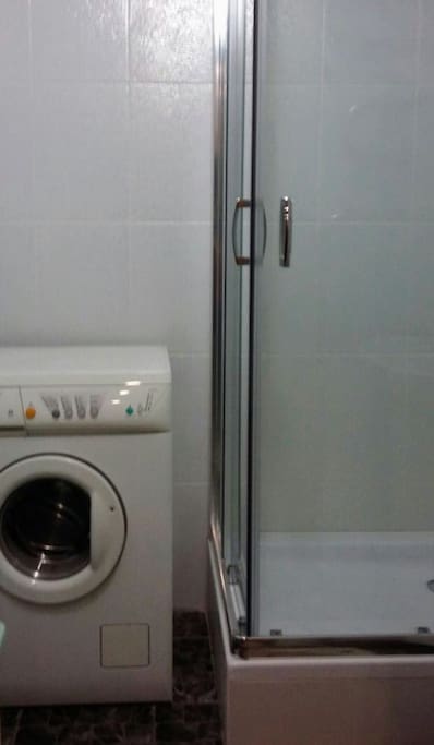 bathroom with a shower and washing machine