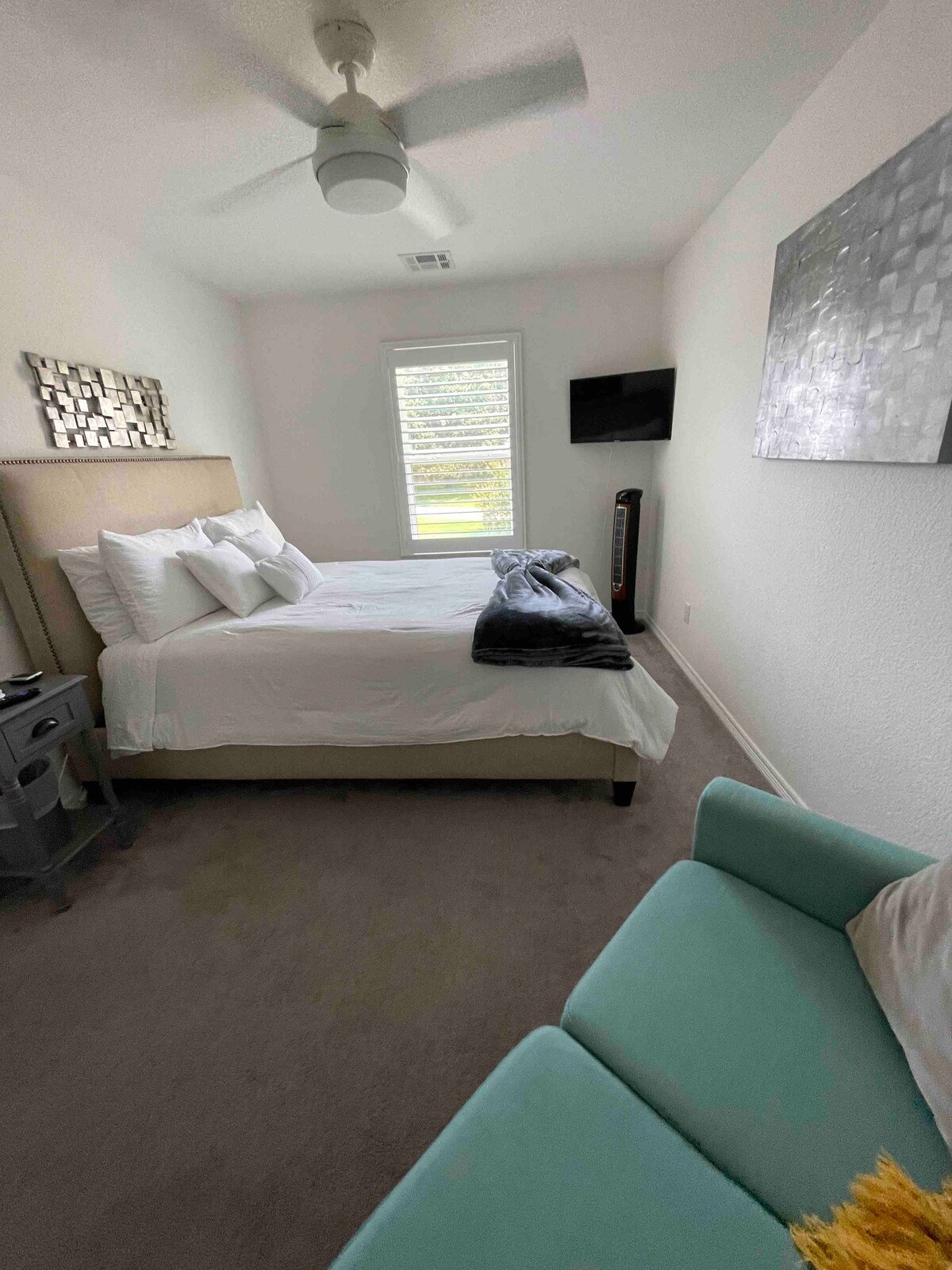 标准双人床，配有振荡风扇和智能电视。 