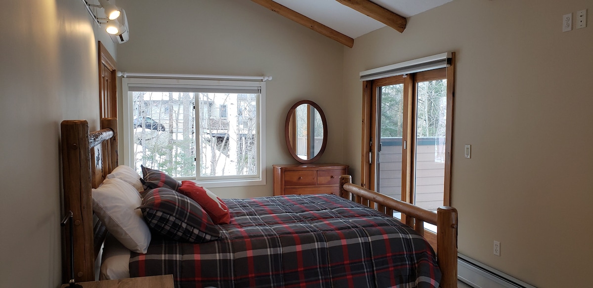 Dhomë gjumi në katin kryesor e përkryer për një familje prej 4 personash!  Kjo dhomë ka një krevat dopio dhe krevat dopio me trungje dopio poshtë.  Shijo pamjet e malit nga 2 dyert rrëshqitëse prej xhami dhe hyr direkt në verandën e pasme.