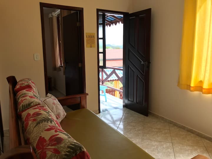 ห้องพักพร้อมเตียงพัดลมโต๊ะพร้อมเก้าอี้ 2 ตัวและทีวี