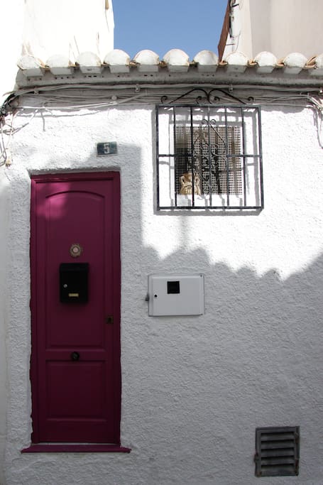 Esta es la fachada de la casa. Se caracteriza por el color de la puerta y el elemento decorativo situado encima del buzón.