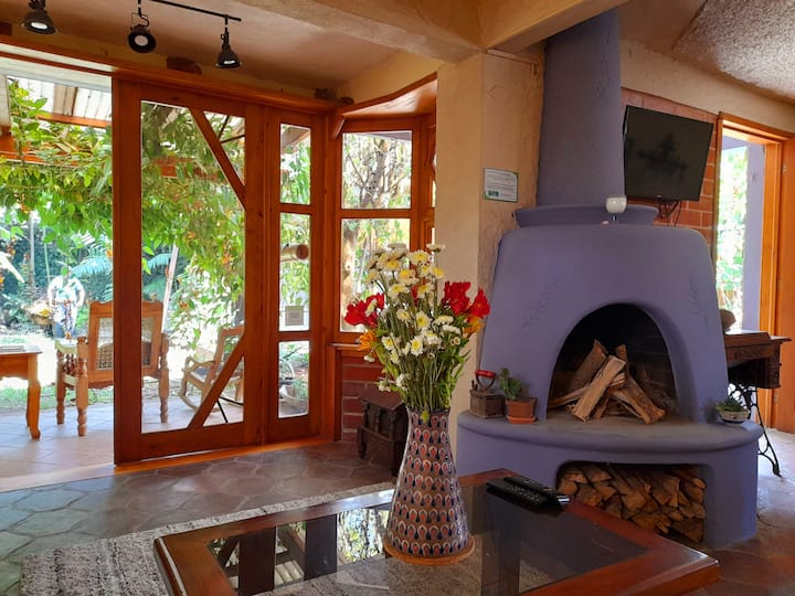 sala de estar con chimenea, televisión inteligente, acceso al jardín y sofá cama.