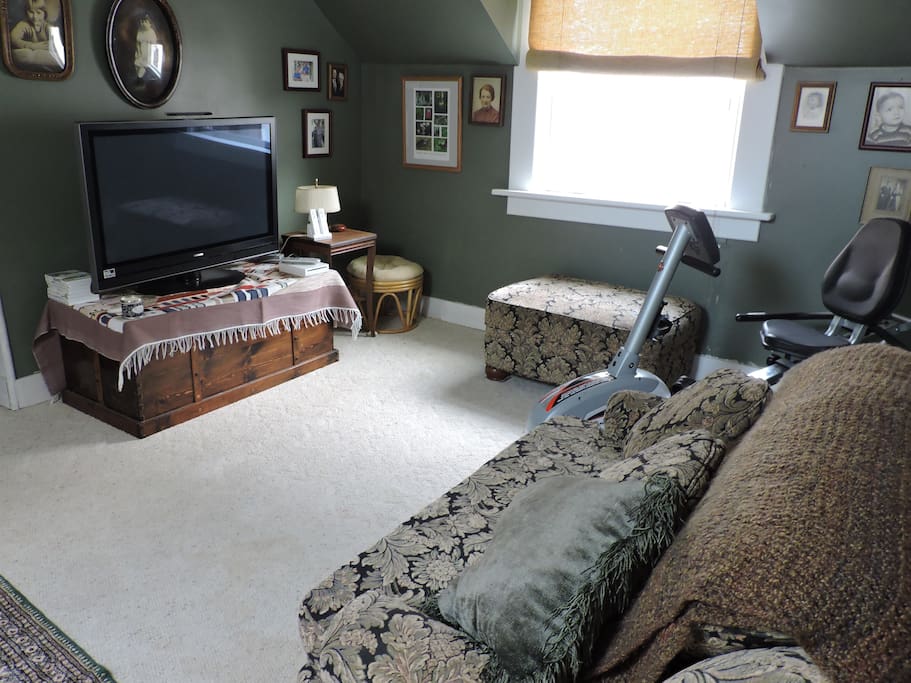 Upstairs living area with recumbent bike and TV.