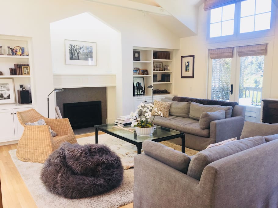 Great room with lots of light, gas fireplace, comfortable seating, television, and two sets of french doors to deck.