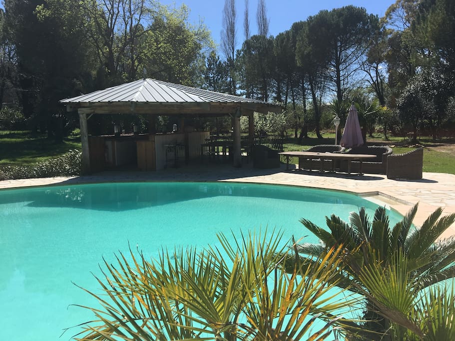 Piscine avec Pool house, salon extérieur, chaises longues.