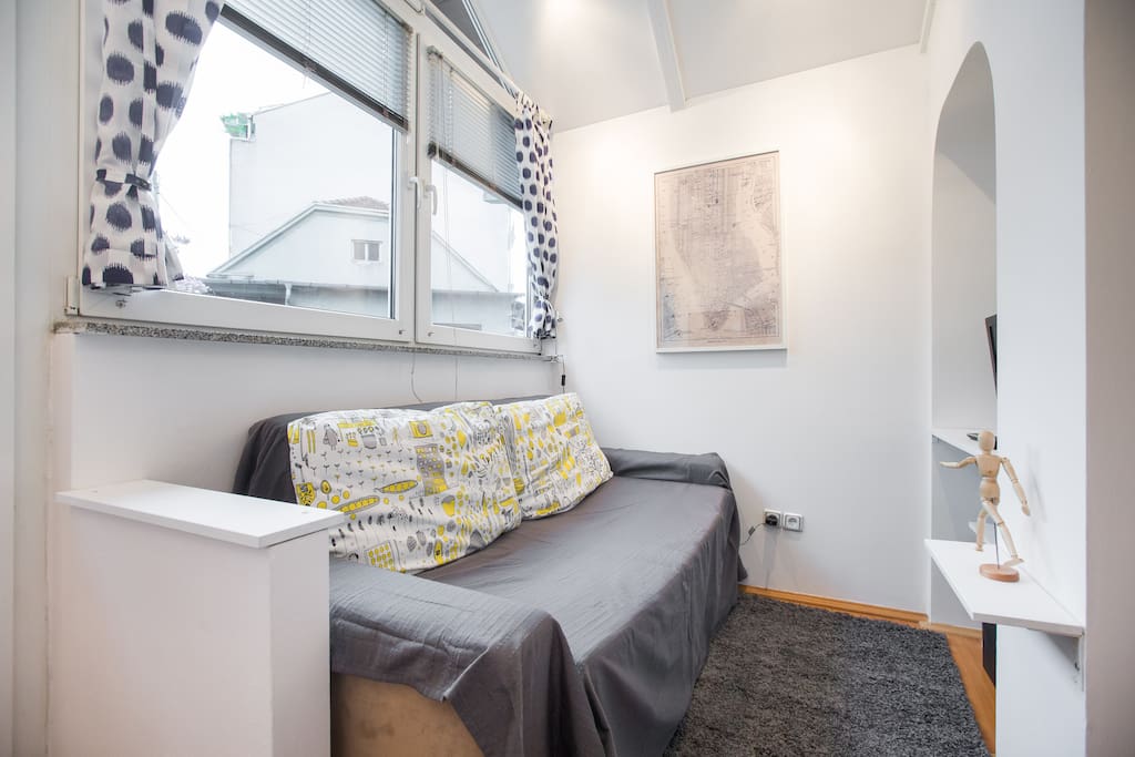 Besides all the natural light, there is a comfortable couch and a TV.