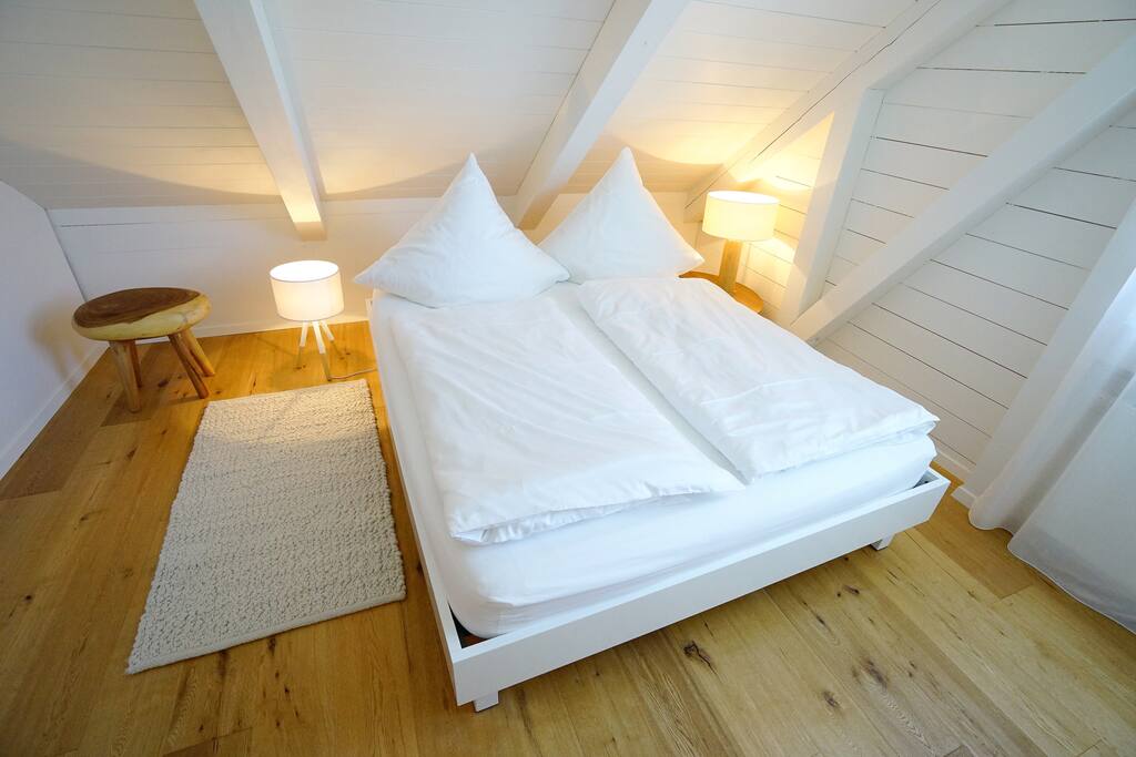Feines Schlafzimmer mit hochwertigem Bett und Damast-
bettwäsche