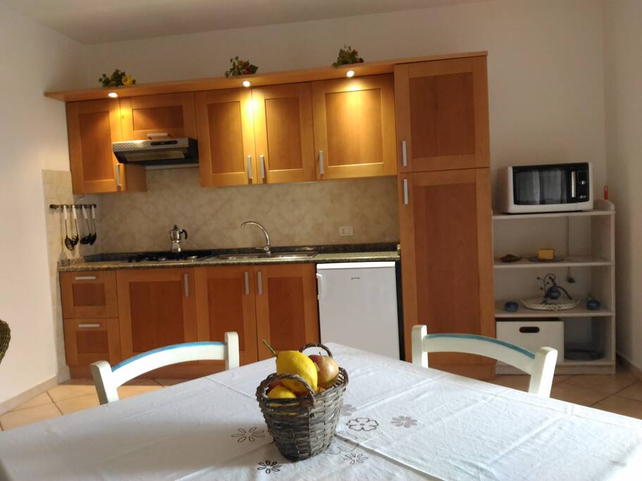 Kitchen with gas hob, fridge, microwave combi and dining table & chairs