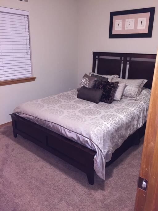 Spacious queen sized bed with comfortable and cozy bedding.