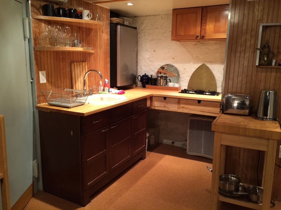 Kitchen with 2-burner stove top, sink, fridge.