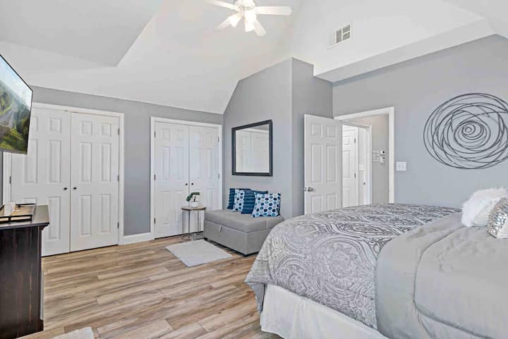 Wake up to the beauty of the lake and start your day feeling like royalty in this luxurious king bedroom with a stunning lake view, smart tv, and seating area for two.