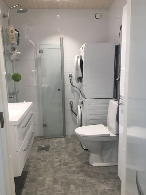Bathroom with shower, washing machine, dryer, toilet