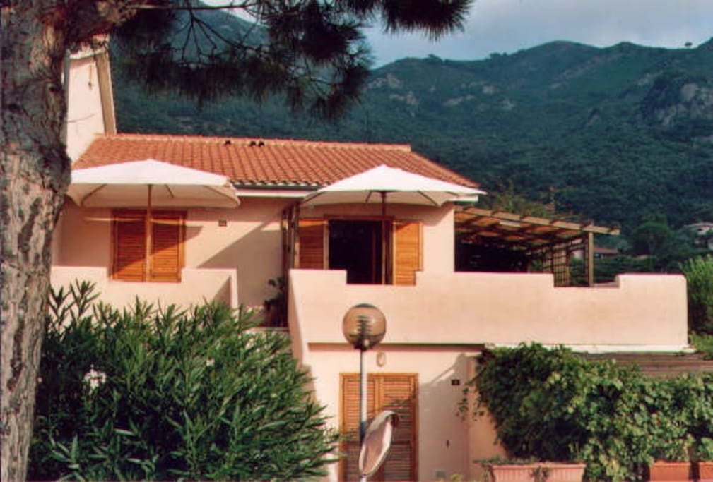 la casa è al primo piano a dex con ombrellone bianco e persiana aperta