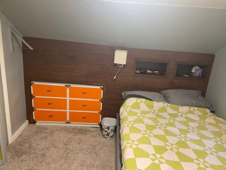 This room can be locked. To the left there is an extendable hanger space if needed. (Silver - folds down). Inside the left head board box is an outlet and USB plug. Open drawer space for your needs - orange dresser. Extra sheets in dresser to.
