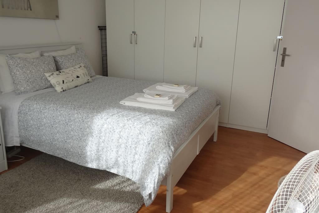 The natural light entering from the large windows of the bedroom.