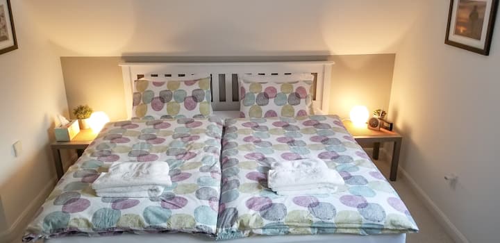 Comfortable and brand new, high quality king size bed from Canada, solid wood! Also new... medium firm (!) mattress, 2 duvets and European bedding.