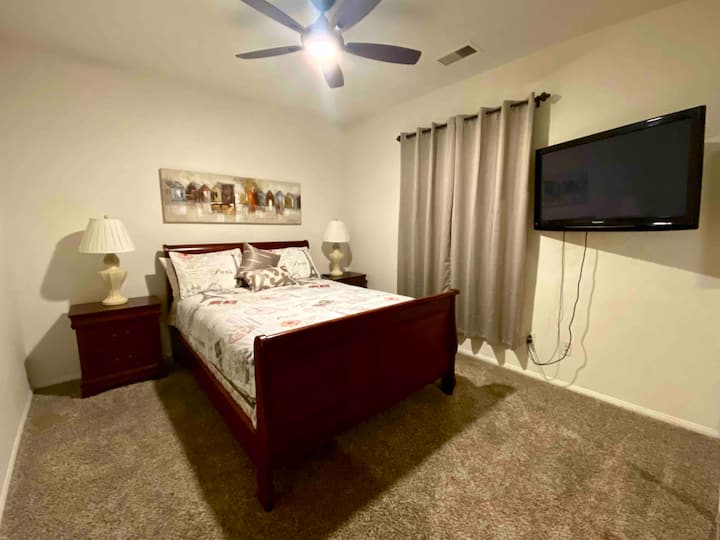 Dormitorio de invitados. Cama tamaño queen. TV de 42 pulgadas. Amazon Fire Stick. Vista lateral al patio.