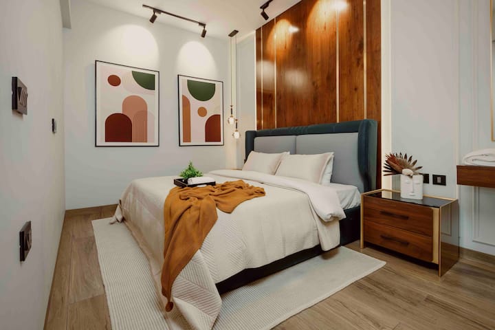 ห้องนอนตกแต่งภายในสีเขียวและไม้ที่สวยงามพร้อมเตียงขนาดคิงไซส์และที่นอนขนาด 8 นิ้วเพื่อการนอนหลับที่ดีที่สุด