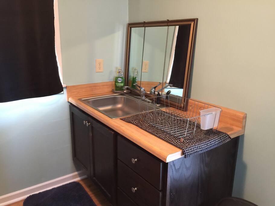 View of other side of kitchen which includes sink and counter space. The sink and mirror doubles as bathroom sink and mirror.