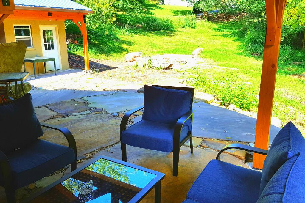 The expansive backyard offers a fire pit, edible landscaping, an area for composting, and a slew of natural stone seating.