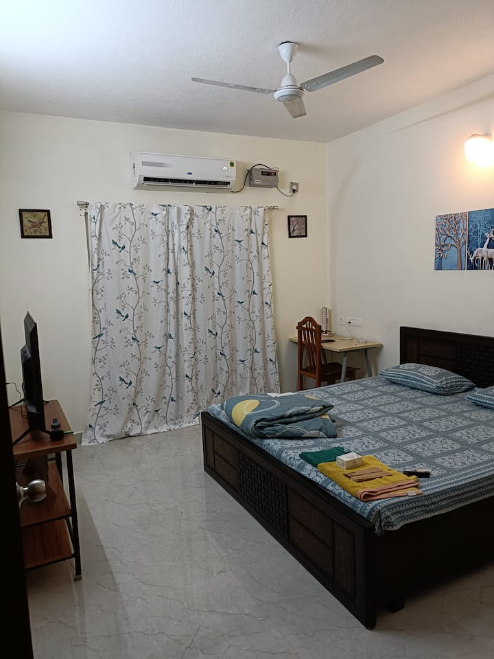 एअर कंडिशनर, एक किंग साईझ बेड, टेलिव्हिजन आणि स्टडी/वर्क कॉर्नरसह ग्राउंड फ्लोअर बेडरूम