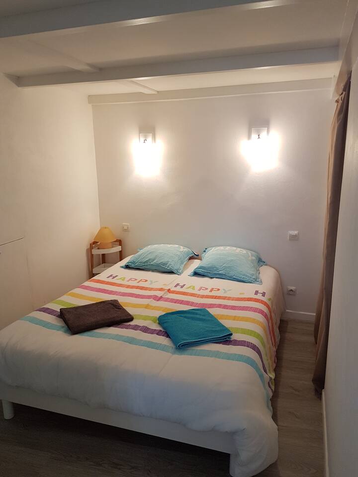 Quarto com uma cama de casal sob o mezanino.