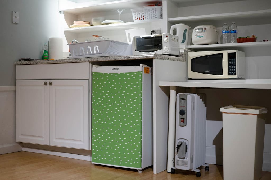 Kitchenette with microwave, toaster, mini oven, electric kettle, and rice cooker.