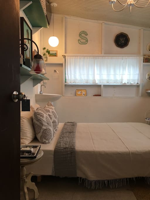 The wooden bedroom surrounded by windows and vintage decor