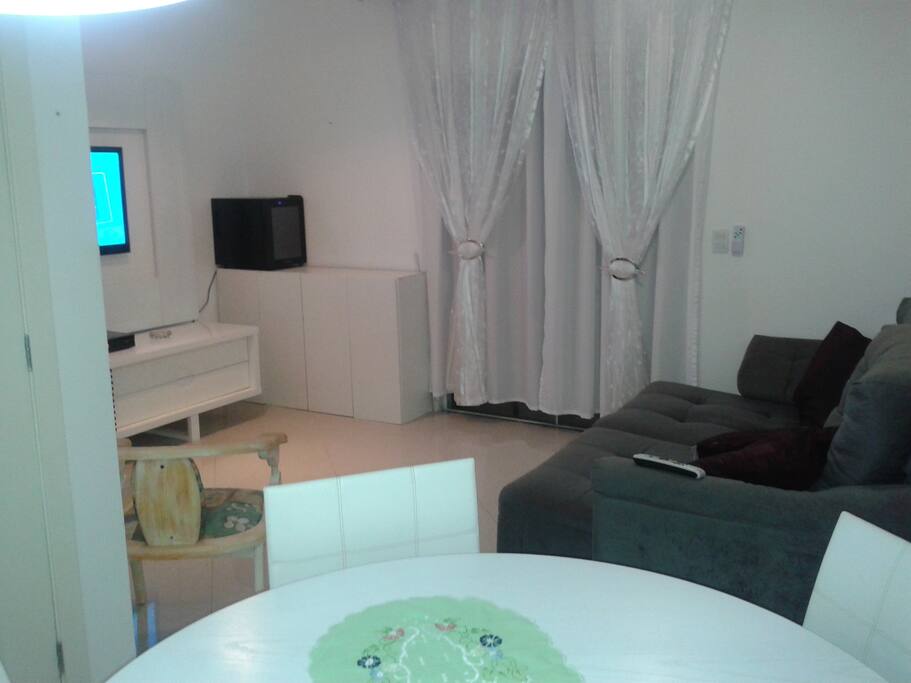 Sala com mesa 4 cadeiras e sofá cama
